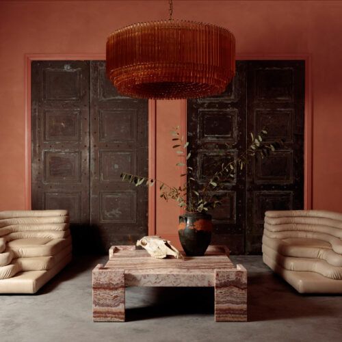 Grande Amber Amaro - large amber drum chandelier in mid-century Murano glass style hanging over a red square marble coffee table