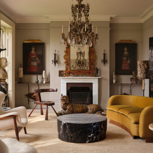 Lighting in a living room with a fireplace, central chandelier and wall lights.